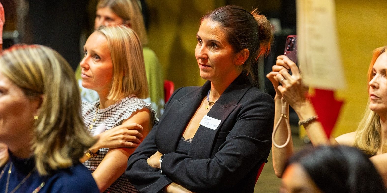 Audience members listening intently at a live talk